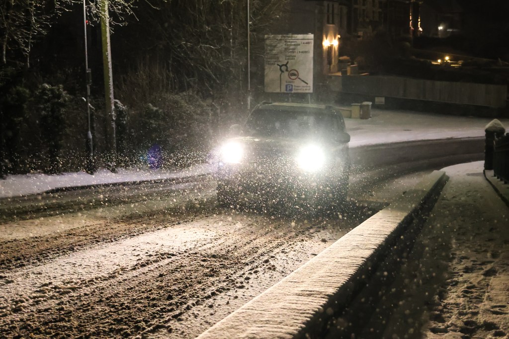 BLACKWOOD - JANUARY 04: A car navigates his way down a hill through snow on January 04, 2025 in Blackwood, Wales, United Kingdom. Temperatures reach -10 C this weekend in some parts of the UK with Amber weather warnings issued by the Met office in place for ice and snow. (Photo by Huw Fairclough/Getty Images)