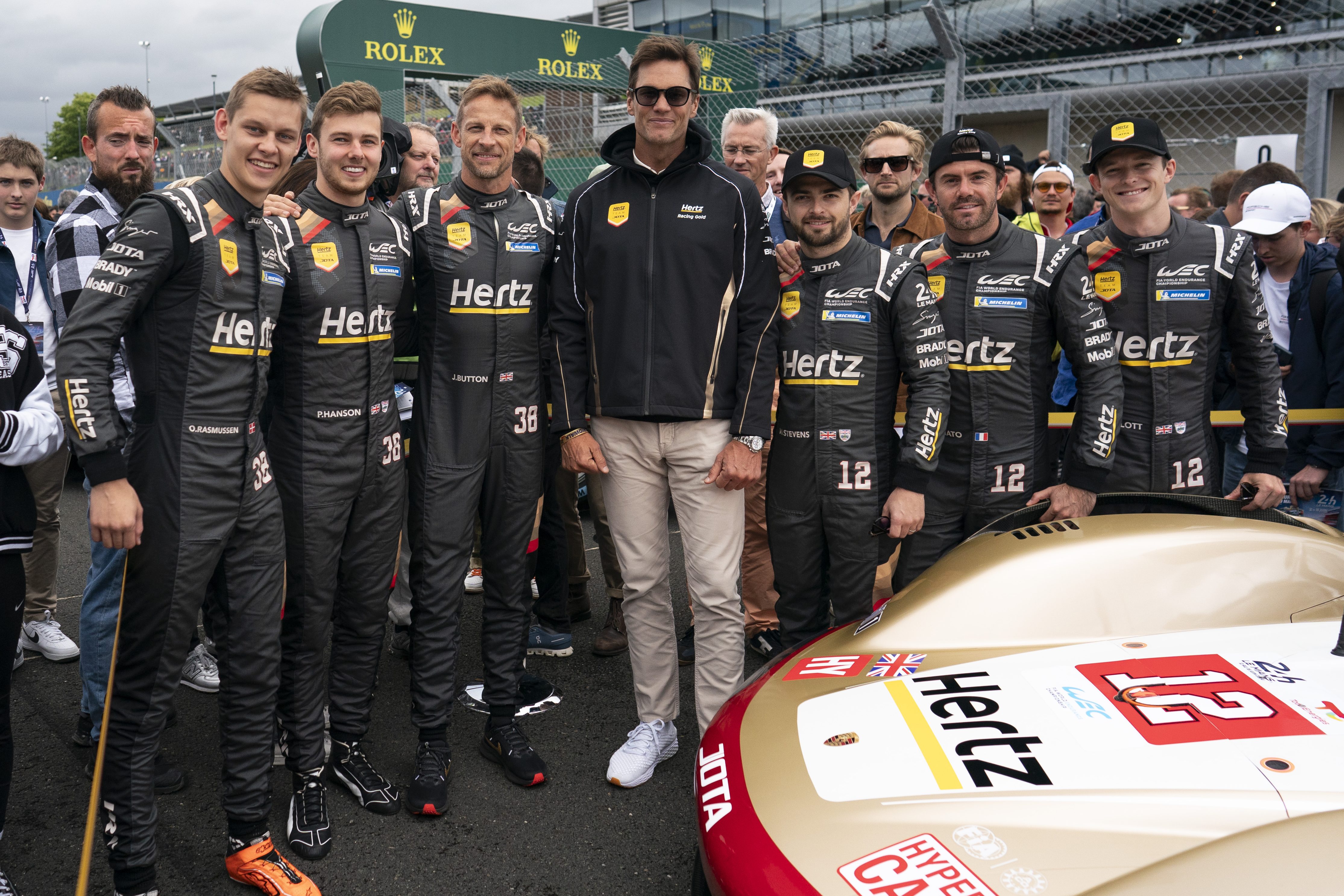 Tom Brady poses with the Hertz Team Jota drivers on the grid at Le Mans 2024