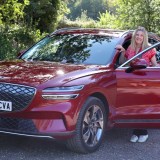 Tina Milton stands by a red Genesis Electrified GV70 for her long term review