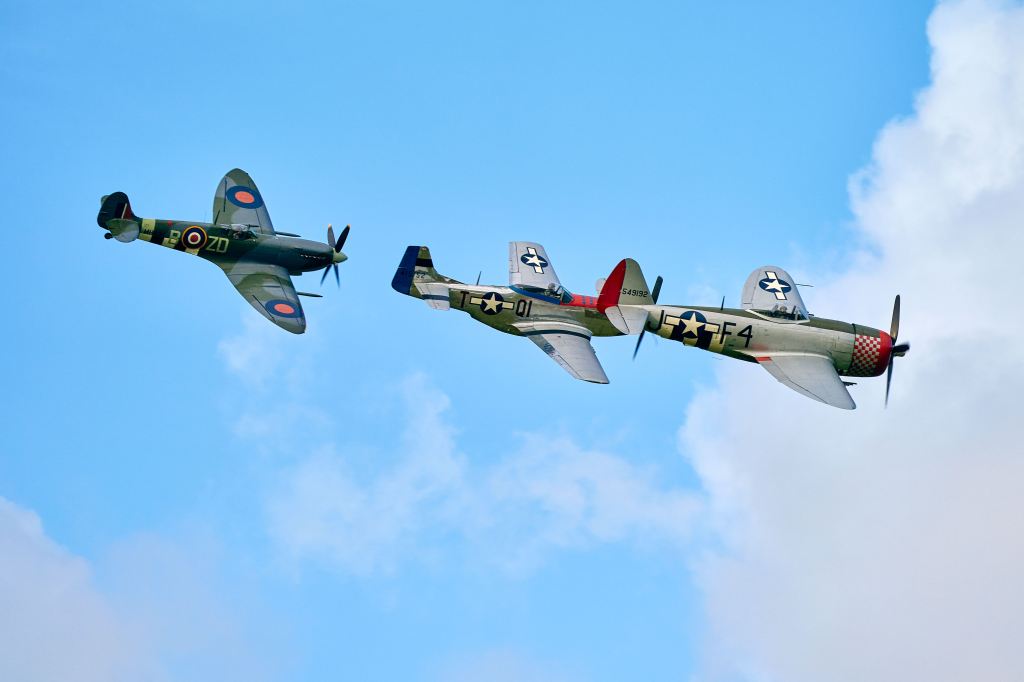 A British Supermarine Spitfire follows an American P-51 Mustang and P-47 Thunderbolt in a US twist on the traditional Revival air display. Photo by Dominic James for Goodwood.