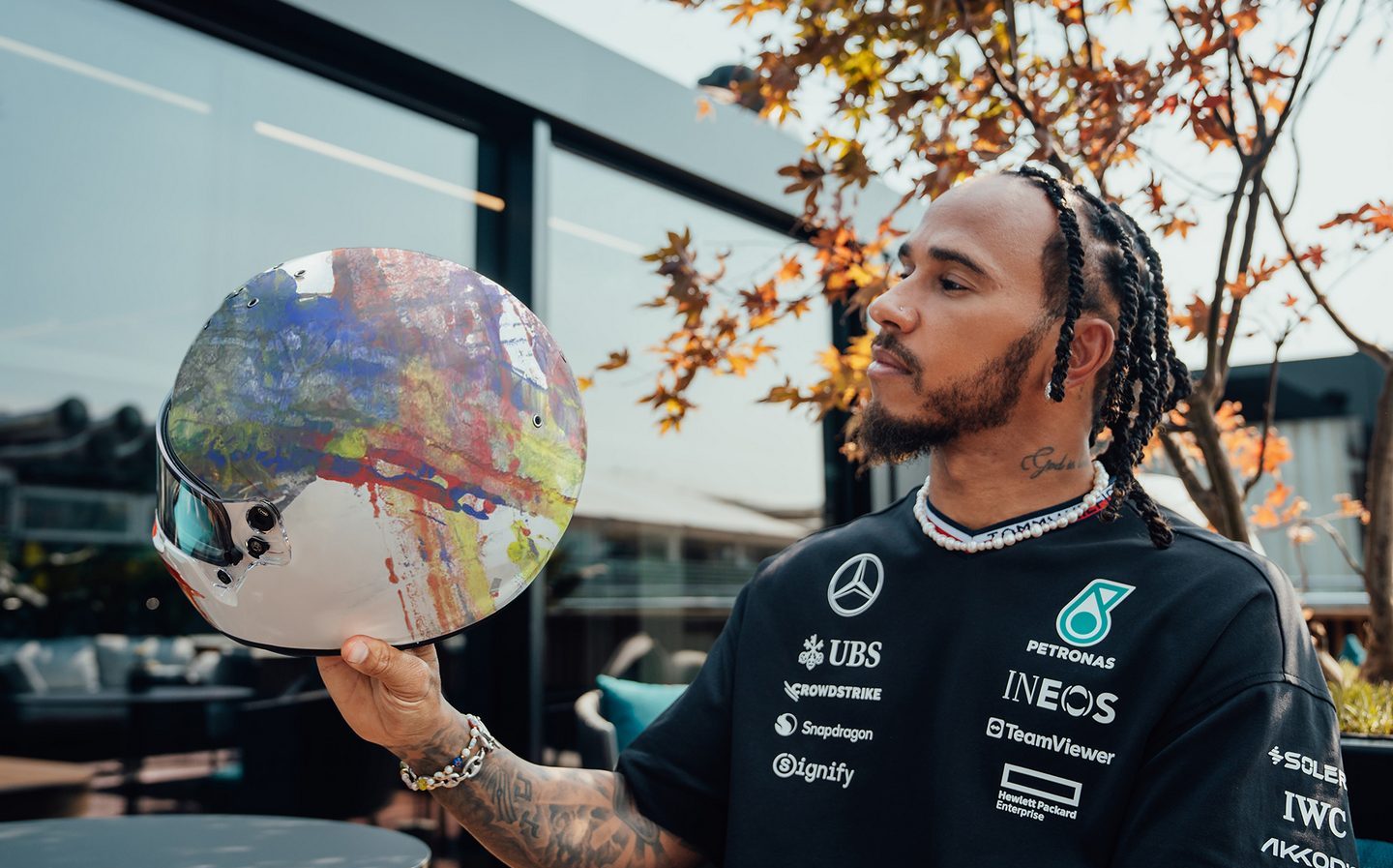 Lewis Hamilton with helmets designed by Ineos competition winners