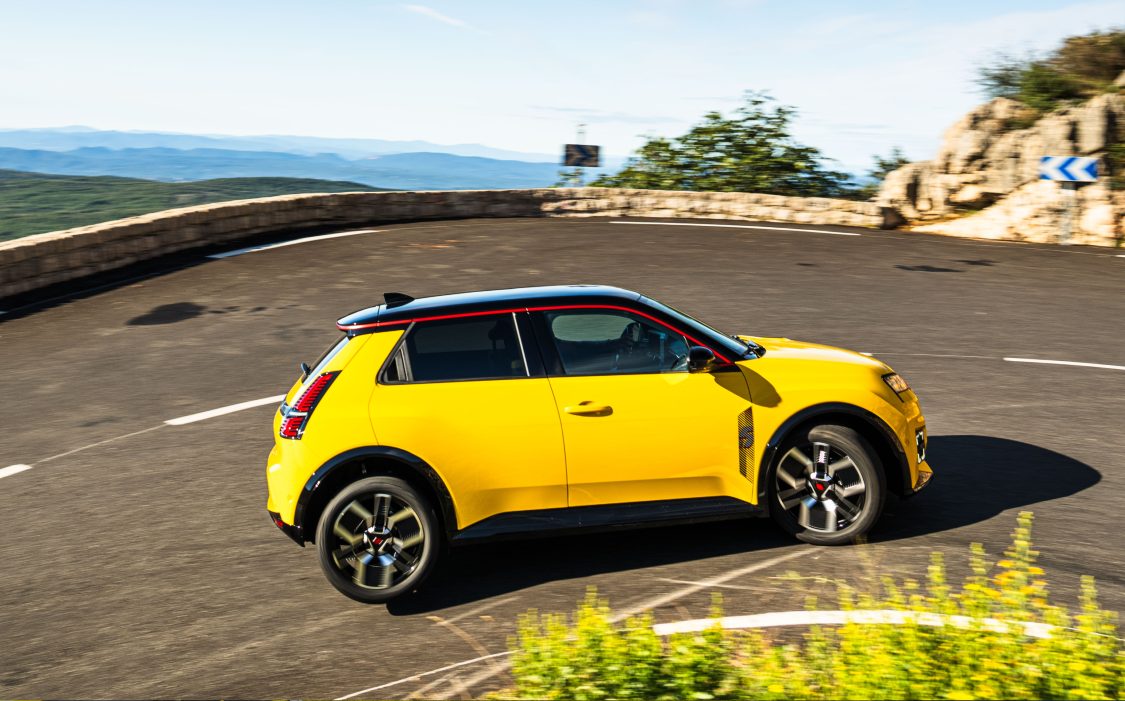 2024 Renault 5 in yellow, on three wheels on a mountain road