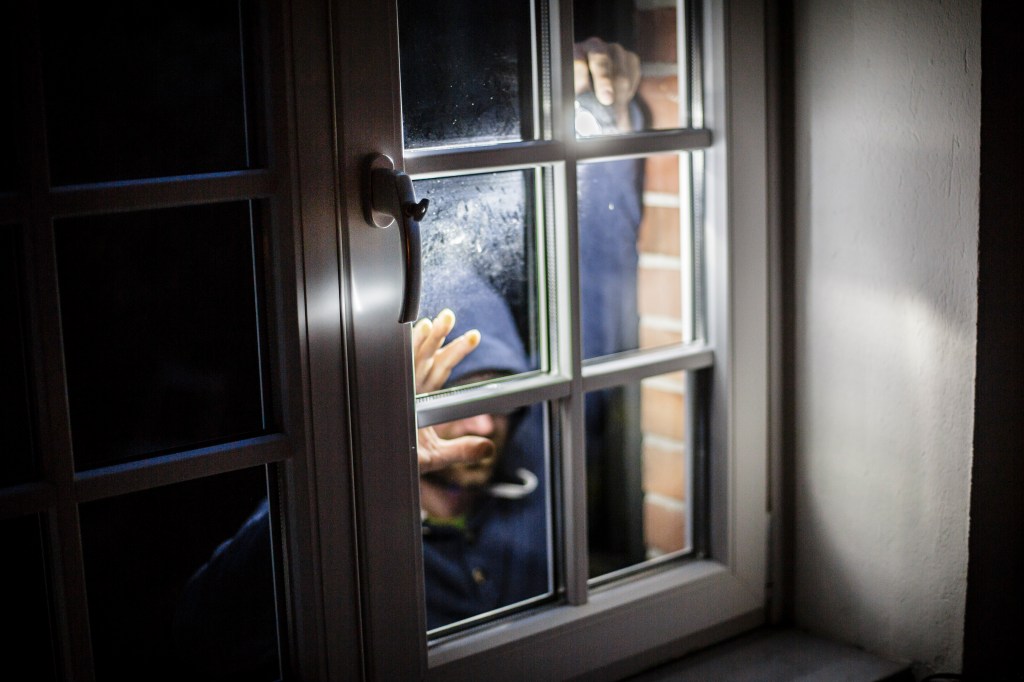 Berlin, Germany - August 11: Staged photo about burglary. A man posing on a house window with a flashlight on August 11, 2016 in Berlin, Germany. (Photo by Thomas Trutschel/Photothek via Getty Images)