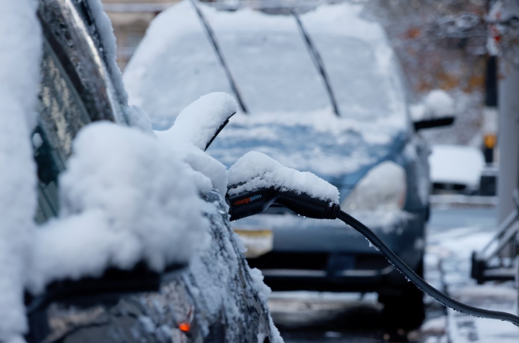 HOBOKEN, NJ - DECEMBER 21: A Tesla electric car recharges its battery at a Charge Point curbside charging station after an overnight snowfall on December 21, 2024, in Hoboken, New Jersey.  (Photo by Gary Hershorn/Getty Images)