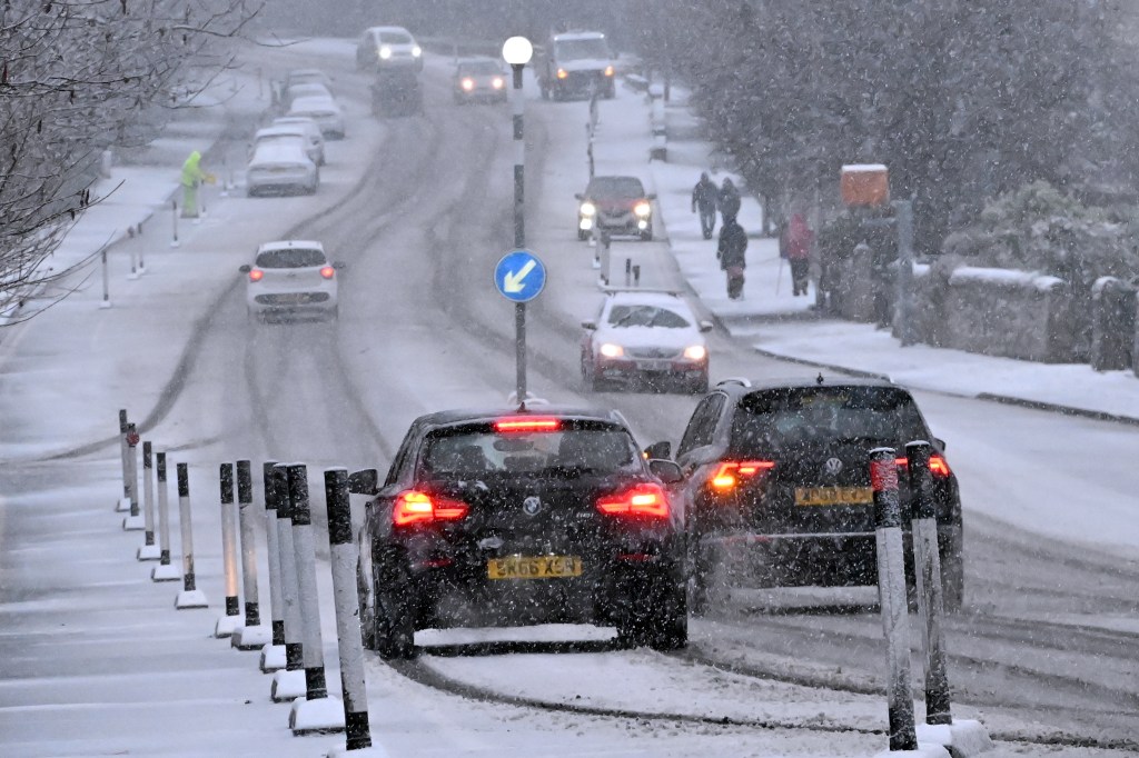 EDINBURGH, SCOTLAND - JANUARY 5: Traffic drives through falling snow on Lanark Road, as wintry conditions close in on the city, on January 5, 2025, in Edinburgh, Scotland. (Photo by Ken Jack/Getty Images)