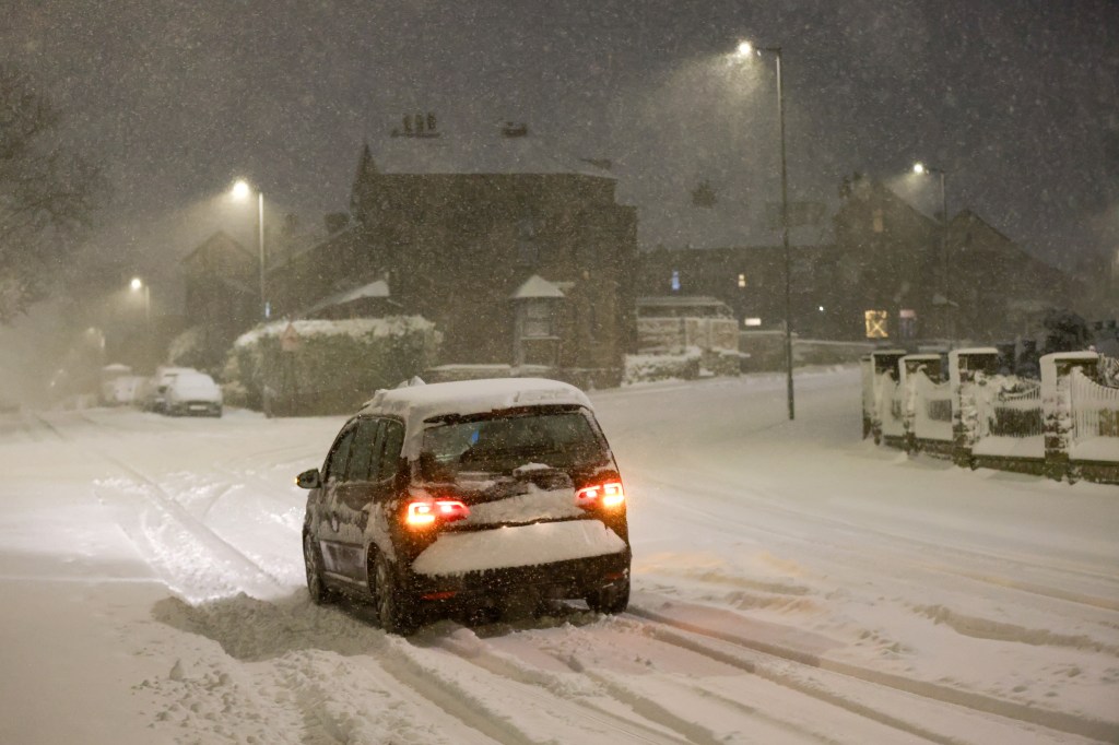 BRADFORD - JANUARY 05: A car drives along a snow covered road on January 05, 2025 in Bradford, . Temperatures reach -10 C this weekend in some parts of the UK with Amber weather warnings issued by the Met office in place for ice and snow. (Photo by George Wood/Getty Images)