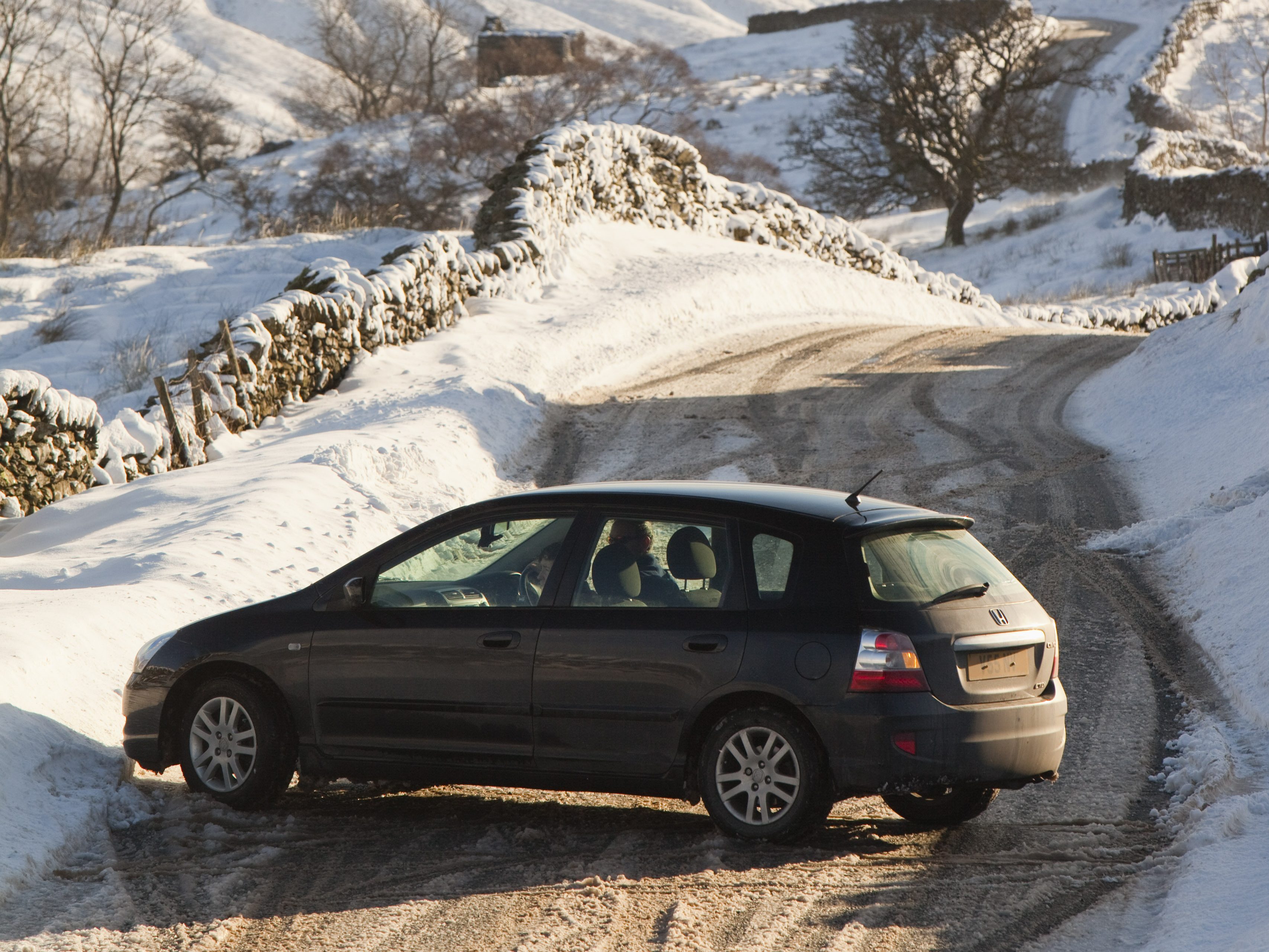 A car that skidded on ice on the Kirkstone Pass road above Windermere after it was blocked by spindrift and wind blown snow, Lake District, UK. (Photo by Ashley Cooper/Construction Photography/Avalon/Getty Images)